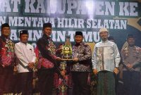 Bupati Kotawaringin Timur Halikinnor menyerahkan piala bergilir MTQ kabupaten kepada Camat Mentaya Hilir Selatan Syahrial selaku tuan rumah/ borneonews.co.id